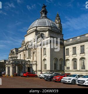 City Hall in Cardiff exterior (grand historic civic centre landmark building, dome, clock tower, entrance portico, bright blue sky, cars) - Wales, UK. Stock Photo