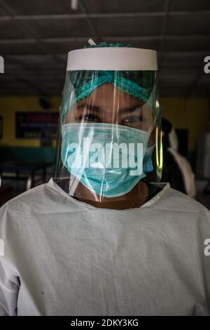 Medan, Indonésie. 16 décembre 2020. Un travailleur de la santé a vu porter un masque facial et un écran facial en service comme mesure préventive contre la propagation de Covid19 à Medan, dans le nord de Sumatra.comme les cas de Covid19 augmentent à Medan, les travailleurs de la santé font passer des enfants par des tests d'écouvillonnage et des analyses de température pour freiner la propagation du coronavirus. Crédit : SOPA Images Limited/Alamy Live News Banque D'Images