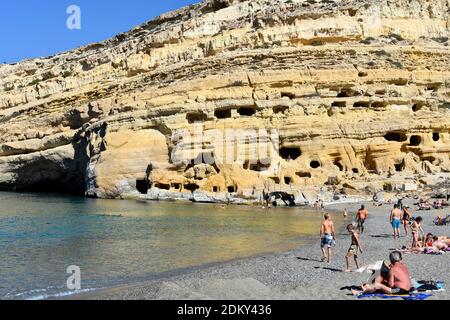 Matala, Grèce - 07 octobre 2018 : personnes non identifiées sur la plage de sable avec des tombes anciennes sur la colline Banque D'Images