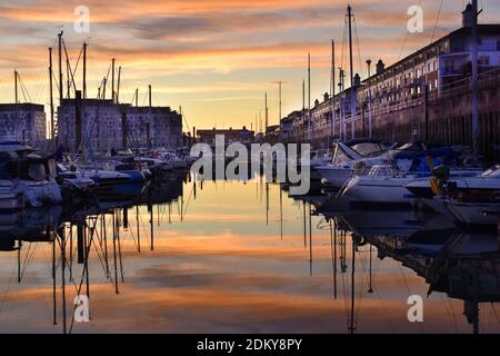 Port de plaisance pittoresque au coucher du soleil avec un ciel vibrant et des reflets sur l'eau calme, Brighton, Sussex, Angleterre, Royaume-Uni Banque D'Images