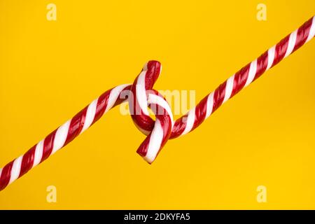 Sucettes de canne à sucre sur fond jaune, bonbons de Noël. Banque D'Images