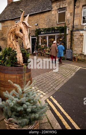 Royaume-Uni, Angleterre, Oxfordshire, Chipping Norton, Cattle Market, les femmes traversant la route à l'extérieur de la maison de Mash et le garde-manger à Noël Banque D'Images