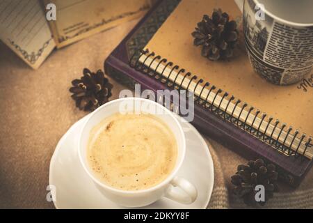 Composition chaleureuse avec livres, décorations et une tasse de café chaud dans une tasse blanche de la photo de service Banque D'Images