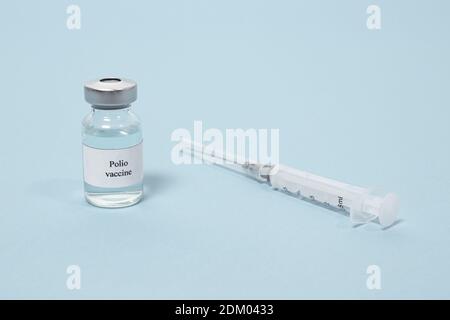 Vaccin antipoliomyélitique et seringue sur fond bleu. Vaccination et prévention poliomyélite. Paralysie infantile. Banque D'Images