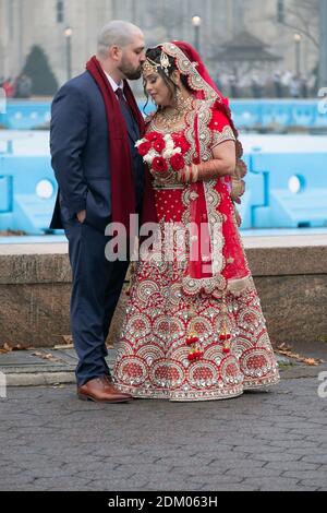 Une mariée hindoue et son marié posent pour des photos quelques heures avant leur mariage. À Flushing Meadows Corona Park, Queens, New York. Banque D'Images