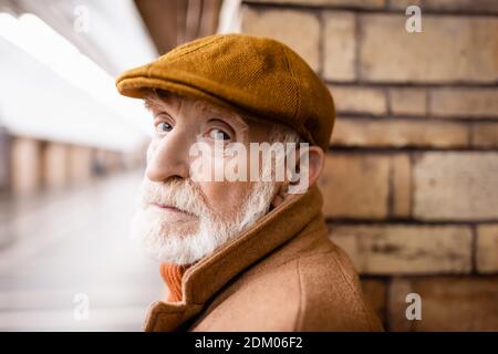 homme âgé en casquette d'automne regardant la caméra dans le métro plate-forme Banque D'Images