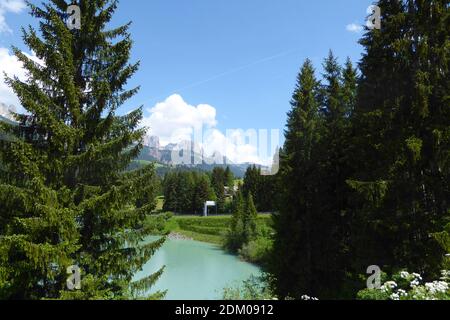 Paysage pittoresque de lac vert et arbres alpins dans le nord de l'Italie surplombant trois sœurs, montagnes dolomite avec fabuleux ciel bleu avec fluf blanc Banque D'Images