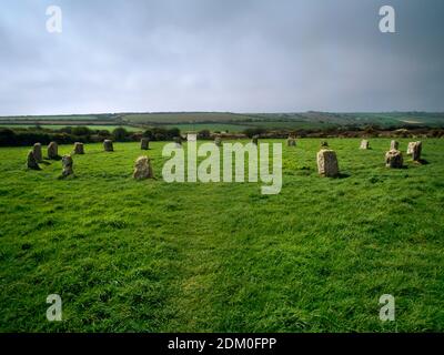 Merry Maidens Stone Circle, Boleigh, Penzance, Cornwall, Angleterre. En regardant vers l'ouest le long de la marche qui coupe à travers le cercle pour pieder et la route. Banque D'Images