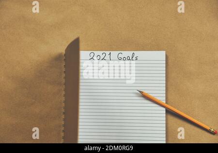 Open Notebook écrivant 2021 objectifs du nouvel an gros plan sur fond marron, Business ou Education motivation, inspiration concept. Objectifs de la nouvelle année et Banque D'Images