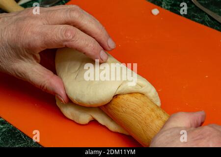 Femme de rouleaux sur la pâte avec un rouleau à pâtisserie Banque D'Images