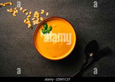 Soupe crémeuse de courge musquée orange vif. Légumes jaune et orange mélangés et crémeux, riches en carotène.graines de citrouille.délicieuse matrice maison Banque D'Images