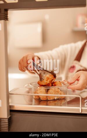 Propriétaire de boulangerie utilisant une balance portant un masque chirurgical. Nouveau concept normal. Banque D'Images