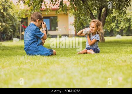 The kids with a kitten are photographed in the backyard Stock Photo