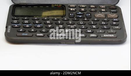 Le clavier d'un ancien organiseur électronique avec écran à cristaux liquides isolé sur un fond blanc. Technologie obsolète des années 90 Banque D'Images