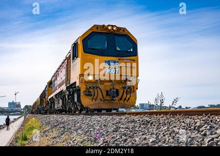 Tauranga Nouvelle-Zélande - décembre 6 2020; charge de transport de locomotives approchant du point de vue bas, en traversant de la ville au côté du mont. Banque D'Images