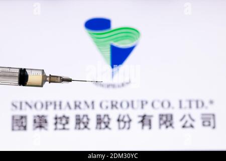 Kathmandu, Nepal - December 15 2020: Closeup of Syringe Injection full of vaccine against Sinopharm Logo. Stock Photo