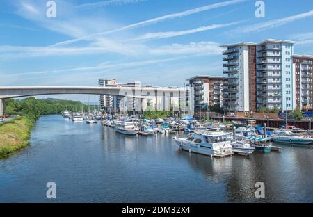 Le port de plaisance le long de la rivière Ely, Cardiff, ainsi que de nombreux bateaux amarrés, des appartements et un pont enjambant la rivière Ely par une journée ensoleillée Banque D'Images