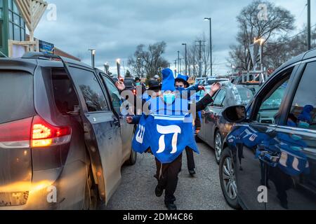 Southfield, Michigan - les garçons dansent entre les voitures alignées pour une voiture Top Menorah Parade la quatrième nuit de Chanukah. Banque D'Images