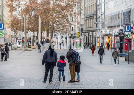 Munich, Bavière, Allemagne. 16 décembre 2020. Une famille regarde dans une zone piétonne vide de Munich, suite à des restrictions strictes en matière d'anti-coronavirus. Scènes de la zone piétonne du centre-ville de Munich, Allemagne. En général, cette région est remplie de clients de vacances et de ceux qui se socialisent au-dessus de Gluehwein. Cette année, un resserrement national des restrictions en Allemagne a été mis en vigueur aujourd'hui, qui a fermé la plupart des magasins et des écoles malgré un verrouillage partiel, les nouvelles infections du coronavirus ont augmenté régulièrement et le manque de conformité avec les règlements de distanciation et de masque sont apparents. Remarque Banque D'Images
