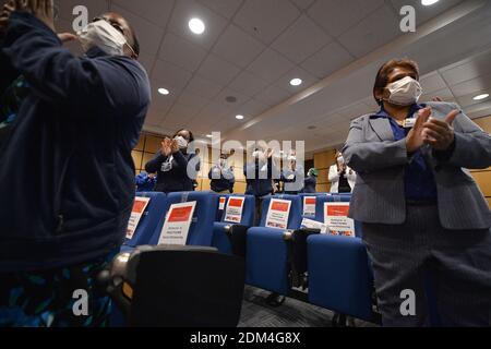 Les travailleurs de la santé se tiennent et applaudissent après que deux travailleurs de la santé, ER Service Aide Kelly Willaim et ER Physician Assistant Veronica Delgado reçoivent les premières doses du vaccin Pfizer-BioNTech COVID-19 dans les hôpitaux sanitaires de New York/Elmhurst, dans le quartier Queens de New York, NY, le 16 décembre 2020. NYC Health Hospitals/Elmhurst est le premier hôpital public de New York à inoculer ses travailleurs de la santé contre le coronavirus, et prévoit de faire vacciner tous ses travailleurs médicaux essentiels dans les 3 semaines. (Photo par Anthony Behar/Sipa USA) Banque D'Images