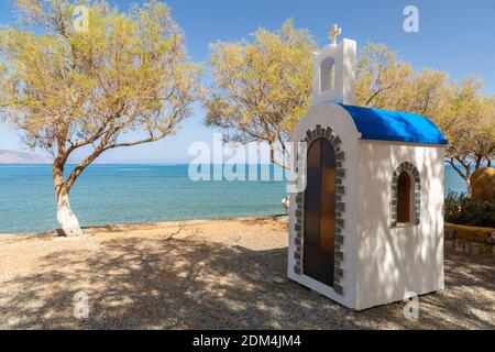 Petit sanctuaire orthodoxe grec blanchi à la chaux au bord de la mer à Tavronitis, Crète, Grèce Banque D'Images