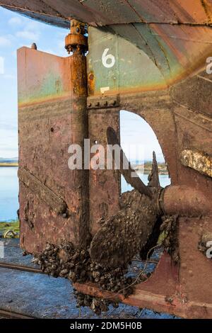 Gouvernail et propulseur, tous deux couverts de barnacles, du MV Kyle, un petit bateau de cargaison clyde Coaster construit en 1872, actuellement en cale sèche en attente de réparation Banque D'Images