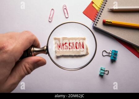 MISSION. Résumé des antécédents professionnels. Main de l'homme, tenant la loupe. Banque D'Images