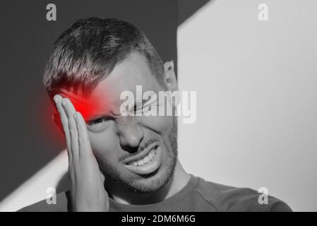 Jeune homme touchant le temple et ayant de forts maux de tête de tension. Maux de tête de groupe Banque D'Images