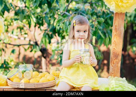 Enfant fille buvez de la limonade naturelle au stand dans le parc. Boisson naturelle rafraîchissante en été, limonade. Eau aromatisée à base de fruits Detox, cocktail dans un bevera Banque D'Images