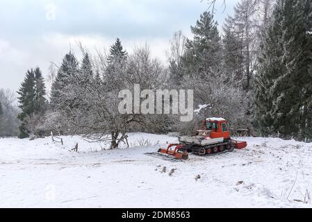 Tondeuse à neige garée sur une piste de ski dans une montagne à hiver Banque D'Images