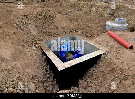 Les vannes à obturation à siège résilient relient la conduite d'alimentation en eau dans le bunker en béton sur le site de construction. Solutions pour l'eau potable et les eaux usées. Vanne p Banque D'Images