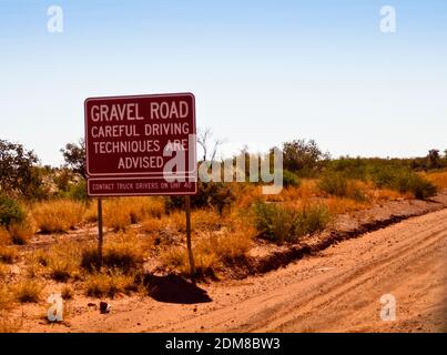 Panneau d'avertissement Gravel Road à la frontière WA/NT sur la route Tanami, Australie occidentale. Banque D'Images