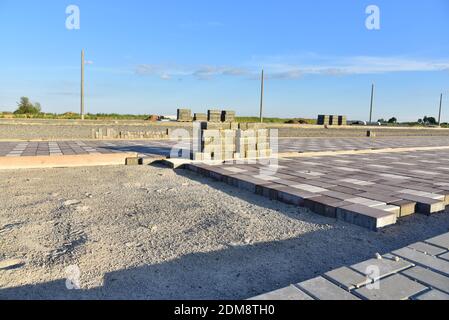 Processus d'installation de briques de pavage dans la zone piétonne de la ville. Pose de dalles et de bordures sur le chantier. Crier le sable pour l'installation Banque D'Images