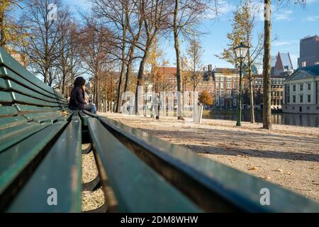 La Haye, novembre 9 2020. La Haye, pays-Bas. Deux femmes discutent sur un banc de parc dans une ville déserte pendant le confinement. Covid-19 pandem Banque D'Images