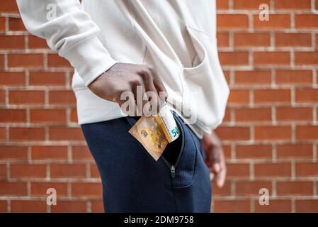 Gros plan sur un homme africain qui a sorti une facture de 50 euros d'une poche Banque D'Images