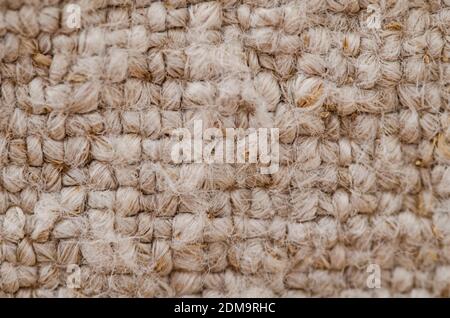 Un gros plan de laine tricotée texture rugueuse. Tissu beige à motifs carrés Banque D'Images