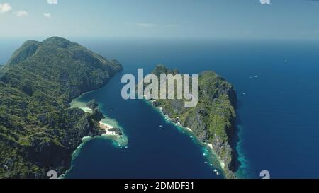 Vue aérienne des îles El Nido sur la baie bleue. Les îles de montagne verdoyantes avec forêt tropicale à la plage de sable. Magnifique paysage marin avec des îlots de verdure de l'archipel des Philippines. Tir de drone cinématographique Banque D'Images