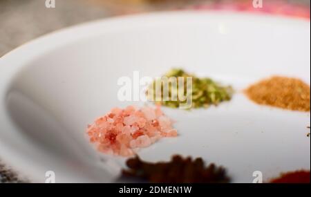 Pink marine salt crystals on a white dish. Extreme close up. Banque D'Images