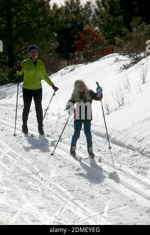 Deux skieurs de fond se dirigent sur des pistes soignées dans un domaine de ski nordique à Chelan, Washington. Echo Ridge est une zone de loisirs multi-usage qui était Banque D'Images