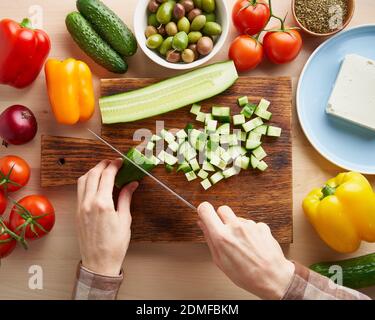 Recette étape par étape pour la salade horiatiki, planche en bois pour couper les légumes Banque D'Images