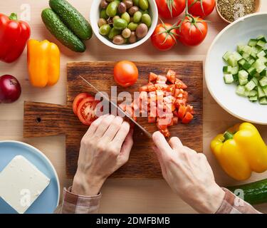 Recette étape par étape pour la salade horiatiki, planche en bois pour couper les légumes Banque D'Images