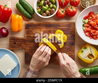 Recette étape par étape pour la salade horiatiki, planche en bois pour couper les légumes Banque D'Images