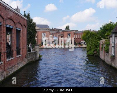 BRUGES, BELGIQUE - 10 mai 2019 : Belgique, Bruges, 10 mai 2019,131, p. 100, bâtiments en briques rouges du canal, en partie avec des plantes grimpantes surcultivées sur la rive Banque D'Images