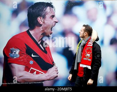 Voici la sélection de photos de l’année par l’agence de presse de l’AP. Un fan de Manchester United admire une photo de l'ancien joueur Gary Neville devant Old Trafford. Neville est photographié pour célébrer une victoire de derby à Manchester City en 2010. Il s'est avéré être un autre jour victorieux pour United comme ils ont écrasé Norwich 4-0 grâce à un corset Marcus Rashford et des buts d'Anthony Martial et Mason Greenwood. Banque D'Images