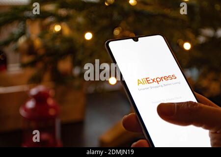 Application Alibaba sur le smartphone avec fond de Noël, achats en ligne, service de vente en ligne basé en Chine appartenant au Groupe Alibaba Banque D'Images