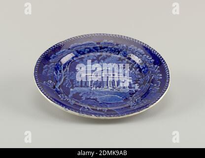 Assiette, faïence émaillée avec décoration bleue à imprimé transvasé, sous-glaçure, fond plat, côté concave. Décoration avec vue sur une villa dans le Regents Park, Londres, avec des arbres et des personnages. Bord avec motif feuille et point en réserve blanche. Au dos du bord, nom de la décoration sur un rouleau, surmontée par l'aigle américain., Staffordshire, Angleterre, ca. 1820, céramique, Arts décoratifs, plaque Banque D'Images