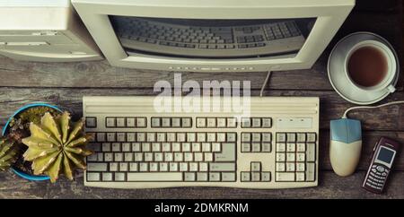 Ordinateur rétro sur un bureau rustique en bois, espace de travail vintage. Moniteur, clavier, souris d'ordinateur, vue de dessus, plat Banque D'Images