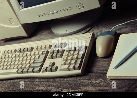 Ordinateur rétro sur un bureau rustique en bois, espace de travail vintage. Moniteur, clavier, souris d'ordinateur, vue de dessus, plat Banque D'Images