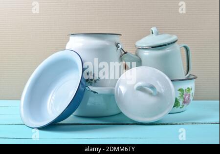 Beaucoup de plats émaillés sur une table bleue. Batterie de cuisine de style rétro Banque D'Images