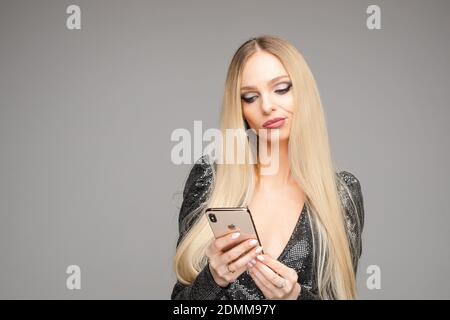 Fille avec doute visage regardant le smartphone. Banque D'Images